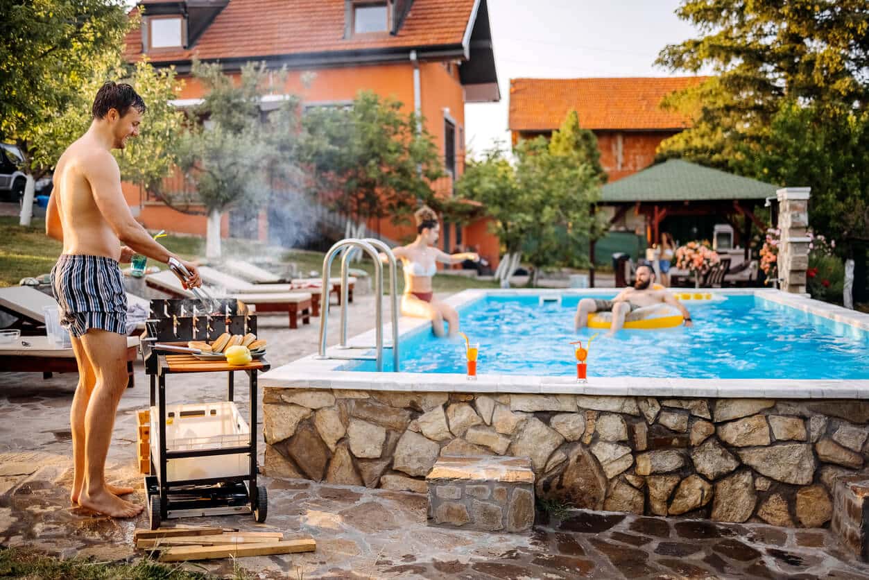 Man grilling at an above-ground pool party