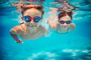 Kids underwater with swim goggles