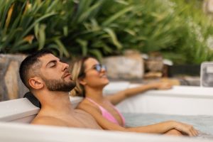 Couple relaxing in hot tub near plants